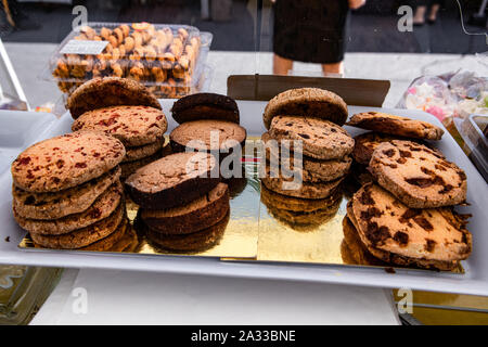 Des cookies aux pépites de chocolat sont vus de près dans une variété de saveurs, affiché dans un compteur sur un stand lors d'un marché fermier local. Banque D'Images