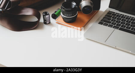 Cropped shot de photographe moderne de travail avec ordinateur portable et les fournitures de bureau Banque D'Images