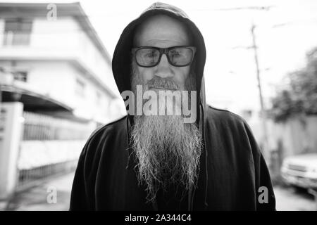 Homme chauve avec maturité longue barbe grise portant des lunettes de soleil en plein air Banque D'Images