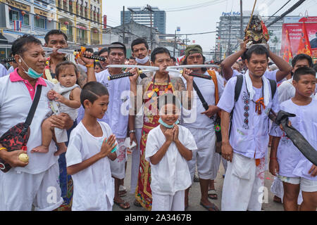 Une procession pendant le Festival végétarien (Festival des neuf dieux de l'empereur) dans la ville de Phuket, Thaïlande, les participants montrant des joues percées d'épées Banque D'Images