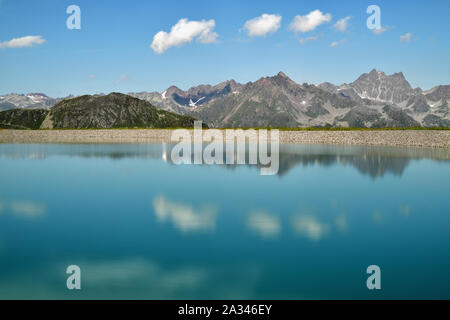 L'eau bleue d'un réservoir artificiel très haut dans les montagnes du Tyrol. Paysage d'été panorama avec reflet dans le lac alpin. Banque D'Images