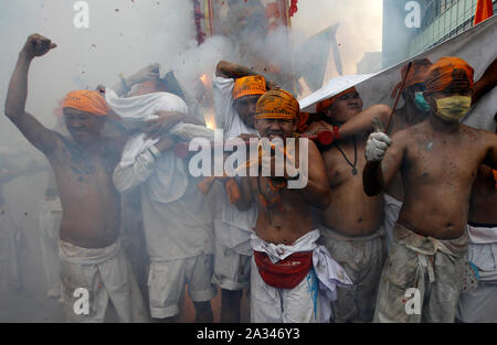 Phuket, Thailande. 05 Oct, 2019. Les dévots de la Chinese Jui Tui shrine réagir tandis que les pétards explosent derrière eux pendant qu'ils prennent part à une procession annuelle célébrant le festival végétarien dans l'île de Phuket. Credit : SOPA/Alamy Images Limited Live News Banque D'Images