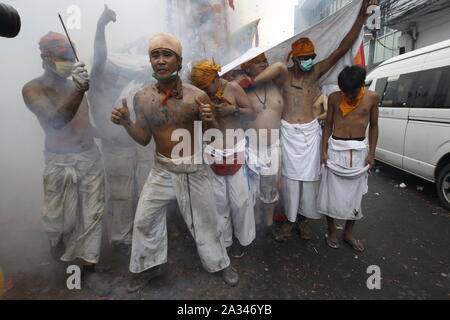 Phuket, Thailande. 05 Oct, 2019. Les dévots de la Chinese Jui Tui shrine réagir tandis que les pétards explosent derrière eux pendant qu'ils prennent part à une procession annuelle célébrant le festival végétarien dans l'île de Phuket. Credit : SOPA/Alamy Images Limited Live News Banque D'Images