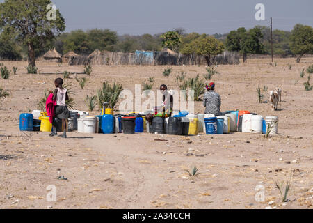 Kapako Kavango, Namibie, de l'Ouest - le 29 juillet 2019 : Les femmes noires d'eau de remplissage des bidons à un puits en milieu rural près de la Namibie La Namibie, Kapako. Banque D'Images