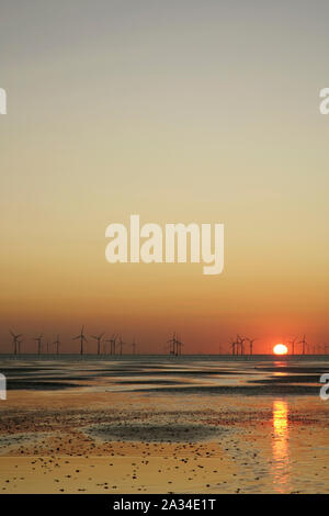 Coucher de soleil derrière des éoliennes offshore au large de Crosby Beach près de Liverpool, Royaume-Uni. Banque D'Images