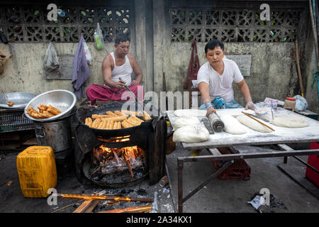 Les gens de la préparation des aliments traditionnels dans la rue birmane de Yangon. Asian street food concept. Banque D'Images