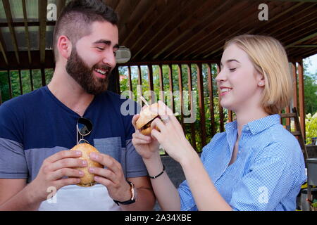 Jeune couple eating hamburger Banque D'Images