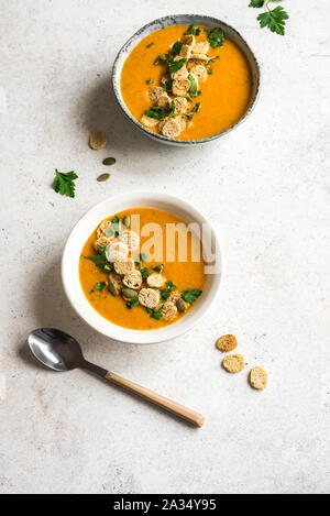 Soupe de légumes avec des croûtons et le persil dans des bols sur fond blanc, vue du dessus, copiez l'espace. Régime alimentaire végétarien saisonnière sain - soupe maison. Banque D'Images