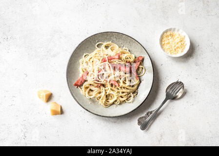 Les pâtes à la Carbonara, spaghetti avec bacon, oeufs durs, fromage parmesan et sauce à la crème. Cuisine italienne Pasta alla carbonara sur blanc, vue du dessus, copiez sp Banque D'Images