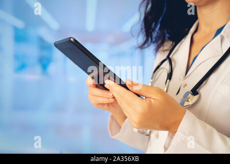 Femme médecin à l'aide de l'ordinateur tablette en position debout tout droit à l'hôpital Banque D'Images