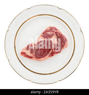 Faux-filet de boeuf cru sur la plaque, isolé sur fond blanc