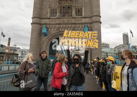 Londres, Royaume-Uni. 5ème Oct, 2019. L'artiste chinoise Badiucao et supporters inscrivez-vous les mains dans une chaîne humaine, une preuve de solidarité avec les manifestants à Hong Kong. Le mur de Lennon, symbole du drapeau Hong Kongs lutte pour la liberté est aussi symboliquement posée. Penelope Barritt/Alamy Live News Banque D'Images