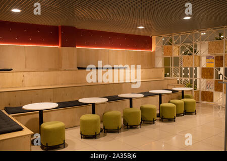 Rangée de chaises de velours blanc par petites tables rondes à l'intérieur de café moderne Banque D'Images