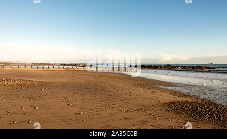 Galets sur une plage de sable brun dans une journée d'hiver ensoleillée, Aberdeen, Ecosse Banque D'Images