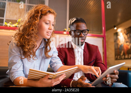 Les jeunes étudiants ou employés multiculturelle réussie à l'écran tactile au Banque D'Images