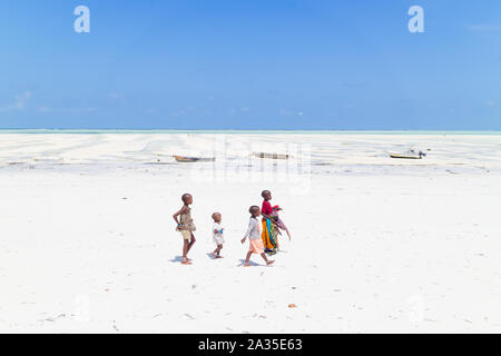 La PAJE, Zanzibar - Feb 9, 2015 : Les enfants de marcher au village de Paje blanc zoom sur la plage à marée basse le 9 février 2015 à Zanzibar, Tanzanie Banque D'Images