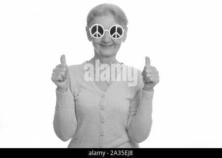 Happy senior woman smiling tout en portant des lunettes avec signe de la paix et giving Thumbs up Banque D'Images