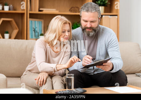Mari et femme mature la lecture des conditions du contrat avant de le signer Banque D'Images