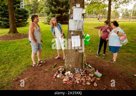 08192019 - Bethel, New York, USA : Un groupe examine les articles laissés à l 'arbre de la paix", au mémorial de Woodstock près du site de l'étape de Woodstock dans l'arrière-plan, le lundi 19 août 2019 à Bethel Woods à Bethel, New York. Organisateur de Woodstock Michael Lang, l'événement a été annulé mais anniversaire les activités ont continué au Arrowhead Ranch, Bethel Woods (le site de l'original Woodstock en 1969), Hector's Inn, et Yasgur's Farm. Banque D'Images