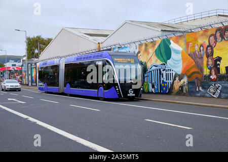 Transit planeur, Van Hool véhicule 18 ExquiCity à Belfast. Bus sur la rue de l'Ouest de Belfast en passant par le mur de la paix Banque D'Images