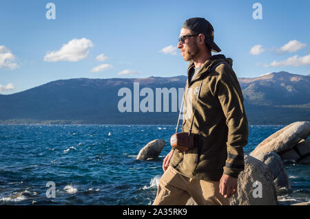 Tahoe City, Californie / Etats-Unis : 27 sept 2019: Un touriste avec un appareil photo à l'ancienne donne sur le lac Tahoe par une journée ensoleillée. Banque D'Images