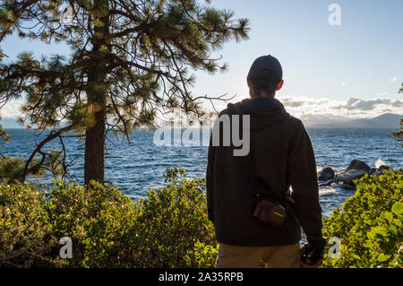 Tahoe City, Californie / Etats-Unis : 27 sept 2019: Un touriste avec un appareil photo à l'ancienne donne sur le lac Tahoe par une journée ensoleillée. Banque D'Images