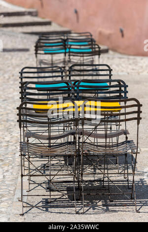 Des chaises et des tables chibby chibby chics et peintes en métal à l'envers d'un café dans la ville grecque de kerkyra, Corfou, Grèce. Banque D'Images