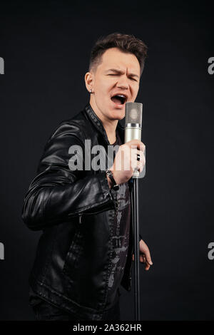 Portrait de l'homme clé basse et chant holding microphone Banque D'Images