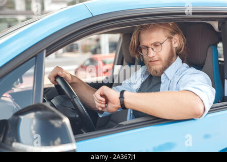 Young adult man sitting in car, à regarder sur Banque D'Images