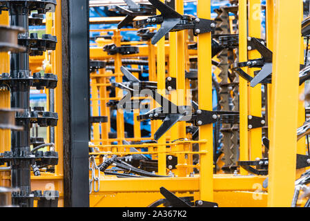 Détail de la machine de l'agriculture dans les temps difficiles. Close up de parties en acier, tubes, engrenages, roues, pneus, Système hydraulique avec la pluie. Banque D'Images