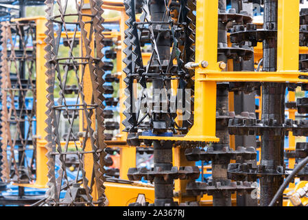 Détail de la machine de l'agriculture dans les temps difficiles. Close up de parties en acier, tubes, engrenages, roues, pneus, Système hydraulique avec la pluie. Banque D'Images