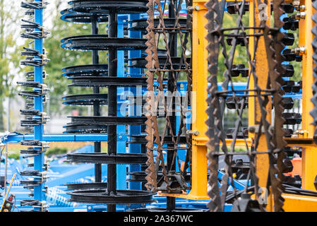 Détail de la machine de l'agriculture dans les temps difficiles. Close up de parties en acier, tubes, engrenages, roues, pneus, Système hydraulique avec la pluie. Banque D'Images