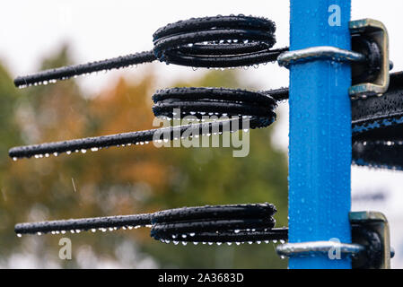 Détail de la machine de l'agriculture dans les temps difficiles. Close up de parties en acier, tubes, engrenages, roues, pneus, Système hydraulique avec la pluie. Banque D'Images