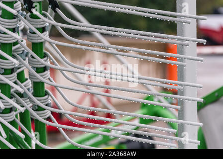 Détail de la machine de l'agriculture dans les temps difficiles. Close up de parties en acier, tubes, engrenages, roues, pneus, Système hydraulique avec la pluie. Banque D'Images