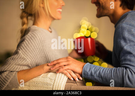 Soirée romantique. Couple drinking coffee contre l'arbre de Noël Banque D'Images