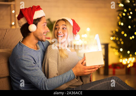 Heureux couple cadeau de Noël dans la salle de séjour Banque D'Images