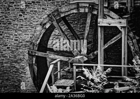 Ancien moulin à eau dans la roue avant du mur de pierre. Noir et blanc. Banque D'Images