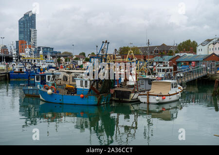 Les bateaux de pêche amarrés au quai une réflexion sur des eaux calmes à camber docks en vieux Portsmouth, Hampshire Banque D'Images