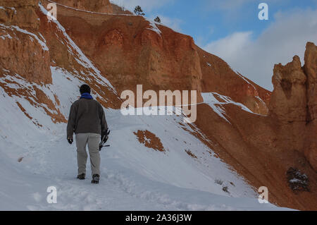 Scène d'hiver de jeune homme randonnée sur les sentiers enneigés de la montagne de Red Rocks à Bryce Canyon Banque D'Images