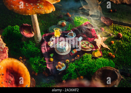 Pique-nique sous toadstool champignons, aliments miniature dans la forêt, tout petit monde concept. Art photo magique en-tête. Banque D'Images