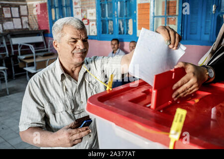 Tunis, Tunisie. 06 Oct, 2019. Un homme tunisien jette son vote à un bureau de scrutin pendant l'élection parlementaire tunisien. Credit : Khaled Nasraoui/dpa/Alamy Live News Banque D'Images