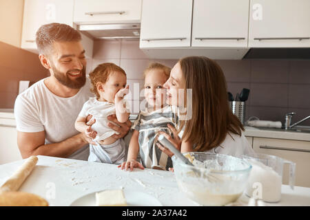 Moment inoubliable avec la famille.la photo en gros, belle femme s'embrasser sa fille, tandis que son mari et son bébé à les regarder Banque D'Images