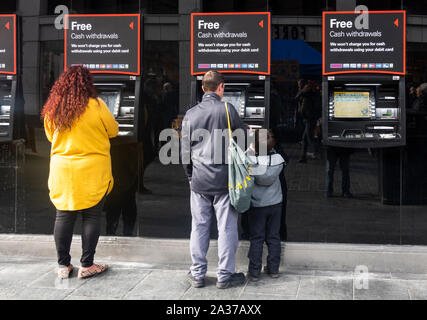 Les gens de se mettre de l'argent à un guichet automatique bancaire à Liverpool Banque D'Images