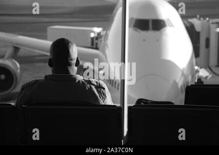 Johannesburg, Gauteng, Afrique du Sud - le 16 juillet 2009 : African passager assis sur lounge en attente de son vol, à la recherche d'avion stationné sur Tambo dans Banque D'Images