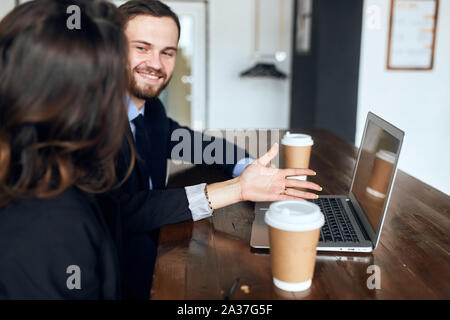 Barbu positif offrant un bon pour un client . homme vendant des articles en ligne, les entreprises . close up side view photo. femme, lui demandant d'accepter avantageux Banque D'Images