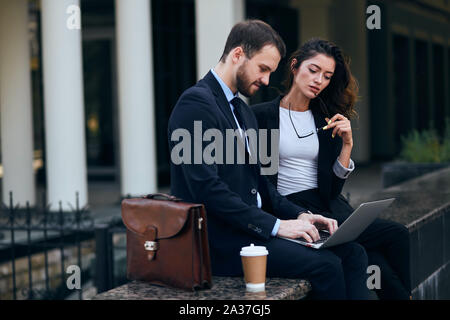 Les jeunes gens d'affaires travailleurs concentrés sur la discussion avec les clients, Close up side view photo Banque D'Images