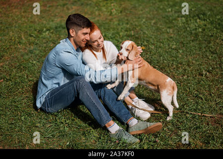 Jeune famille hôtesse leur chien, pleine longueur voir photo Banque D'Images