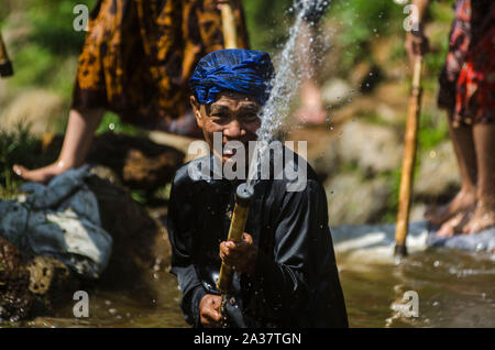 Bandung, Indonésie. 6 octobre, 2019. Un homme avec de l'eau éclabousse une pompe de bambou pour célébrer l'eau de source la préservation des traditions à Lembang à Bandung, Java ouest, Indonésie, le 6 octobre 2019. Credit : Septianjar/Xinhua/Alamy Live News Banque D'Images