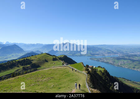 Vue panoramique vue paysage de prairies, des chaînes de montagnes aux cimes enneigées des montagnes du haut de Rigi Kulm, Mont Rigi en Suisse avec le lac des Quatre-Cantons Banque D'Images