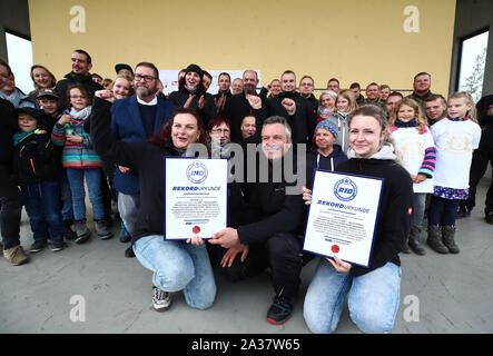 Ronneburg, Allemagne. 06 Oct, 2019. Les membres et collaborateurs de l'association "Nous4Kids' présenter le certificat de record du monde de 994,5 mètres du biscuit 'Kalter Hund'. Les enfants et les employés de l'association "Nous4Kids' produit le biscuit 'Kalter Hund' de chocolat et biscuits et voulait établir un nouveau record du monde avec une longueur totale de 1000 mètres. Les biscuits sont ensuite vendues au profit d'un projet d'aide. Credit : Bodo Schackow Zentralbild-/dpa/dpa/Alamy Live News Banque D'Images